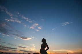 pregnant woman on the background of the evening blue sky