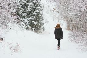 girl in a green jacket in the winter forest