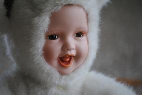 Portrait of the porcelain doll in white, fluffy clothing