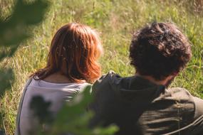 couple sitting on green grass