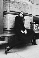 monochrome photo of woman model sitting on bench on street