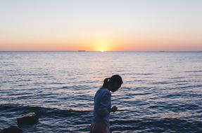 woman walking on beach at sunrise