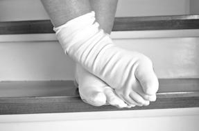 Black and white photo of the feet in white socks, on the stairs