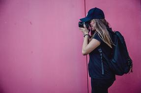 girl with camera near pink walls