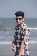 glamorous guy in a plaid shirt on the seashore