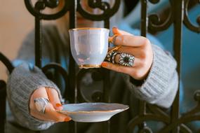 woman is Drinking from the cup with the plate