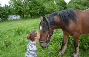 photo of a girl kissing a horse