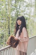 Beautiful, smiling, Asian girl, on the bridge, near the green plants