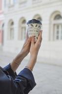 woman holding paper cup of coffee