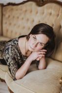 young girl lays on luxury sofa