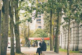 woman talking on cell phone sits on bench in city