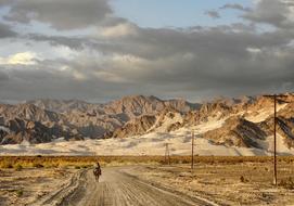 Beautiful landscape of the colorful and beautiful mountains, with the woman rider, in Tinogasta, Argentina, under the cloudy sky