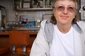 Portrait of the smiling senior woman, with the glasses, in the cafe, in the Grand Canyon, Arizona, USA