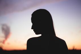 Back view of the girl silhouette, at beautiful and colorful sunset