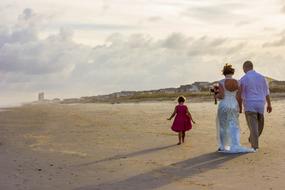 wedding couple with a child on the beach