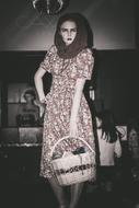 Black and white photo of the beautiful girl, in the dress, with the basket, among the darkness