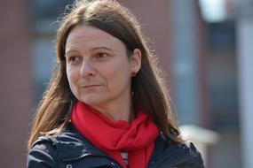 photo of a woman in a black jacket and with a red scarf