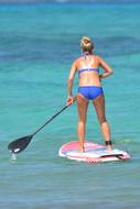 caucasian Woman in Bikini on surf with Paddle