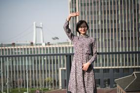 young asian Girl posing in city with hand up
