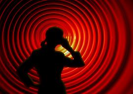 silhouette of a girl with a mobile phone on a background of red rings