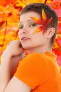 portrait of pretty girl with Autumn leaf on Face