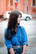 photo of beautiful asian girl in denim shirt on city street