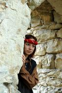 young girl posing in gateway in aged stone wall