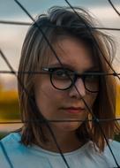 Portrait of serious Young Girl in glasses behind net