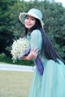 asian girl in green dress with a bouquet of flowers