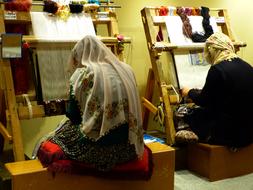 Weavers, two muslim women Tying Carpets