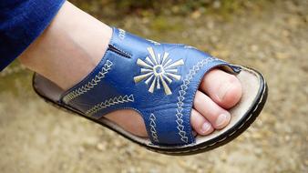female foot in blue and yellow shoes