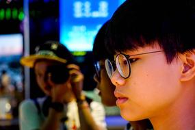 young asian girl in round glasses at reflection of girl with camera