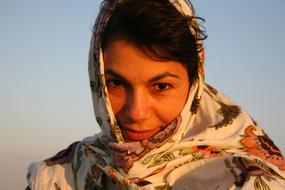 girl in a white headscarf against the blue sky