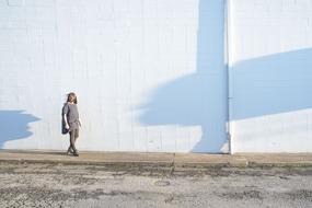 woman walking along White Wall