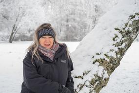 woman with long hair near tree in snowy winter