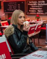 young woman drinking cup with latte