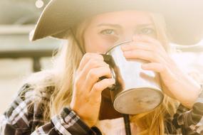 girl drinking from a stainless mug