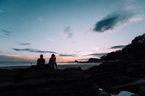 people on sea coast at sunset