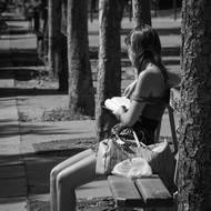 Woman sitting on bench on Street