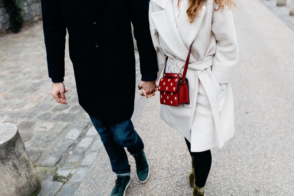Couple in coats, walking on the street, near the pavement