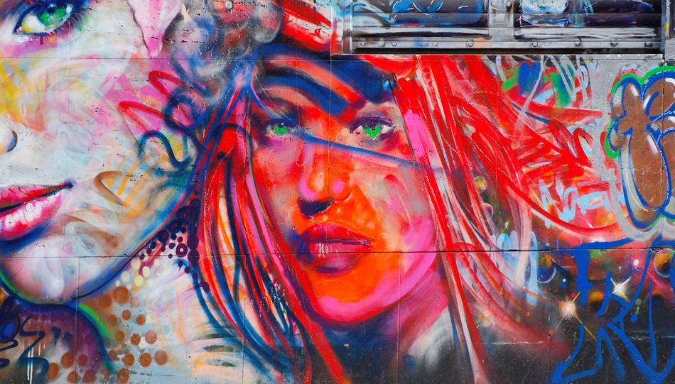 Colorful graffiti with portraits of the women, on the wall with window