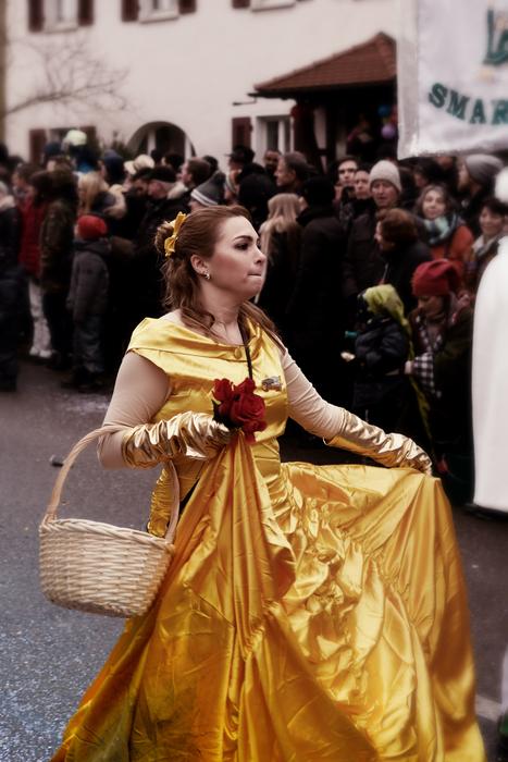 Princess in gold dress, holding wicker bucket among the people