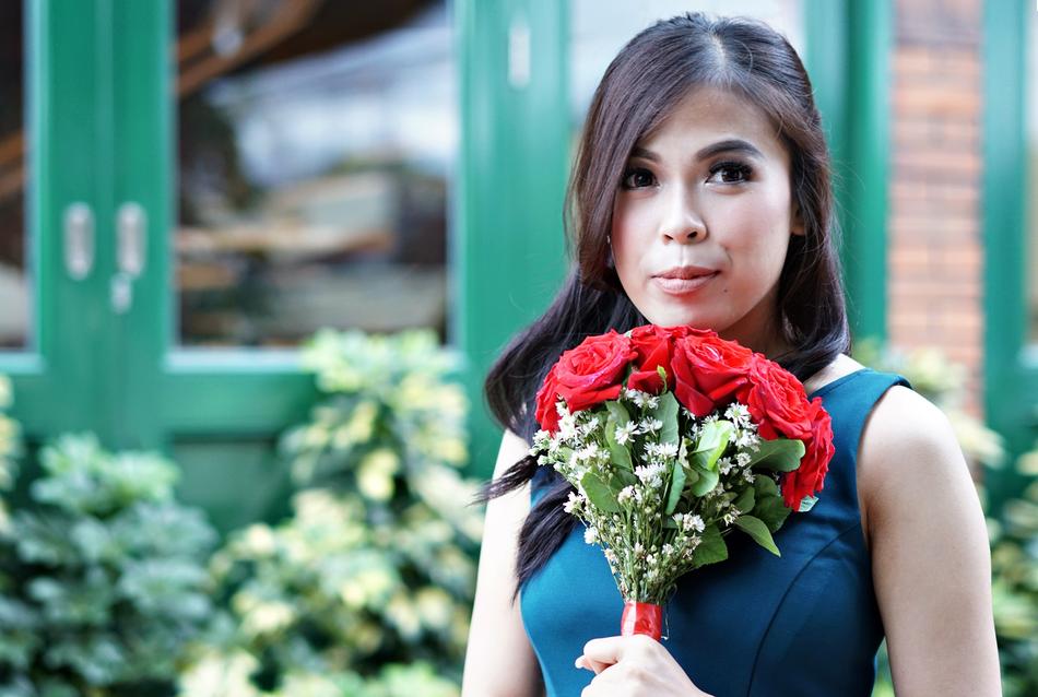 asian woman with bouquet of red flowersr