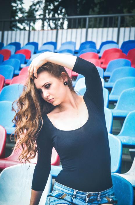 girl on the background of fan chairs at the stadium