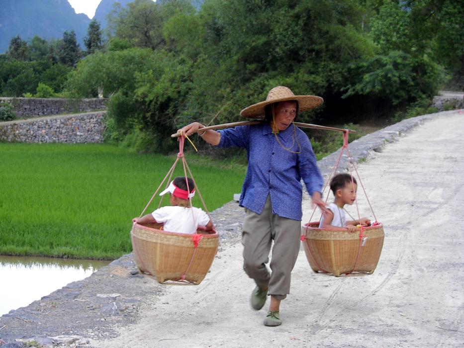woman Carrying children in baskets