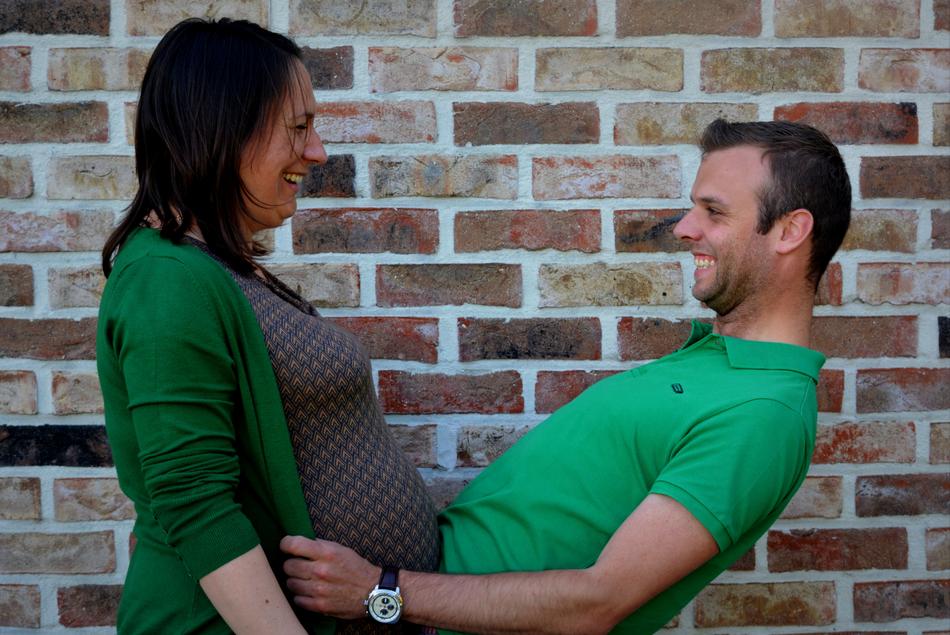 pregnant woman and man on brick wall background