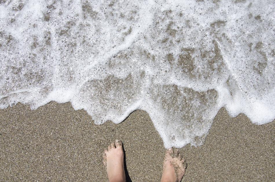 Human feet on Beach at Summer