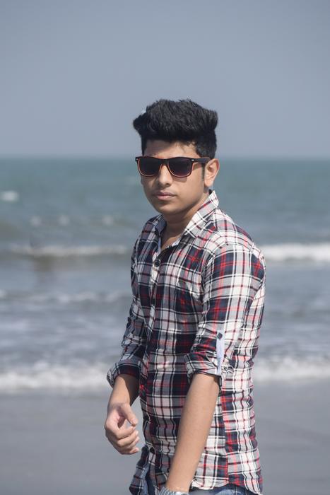 glamorous guy in a plaid shirt on the seashore