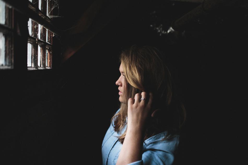 portrait of long haired Woman at window in darkness