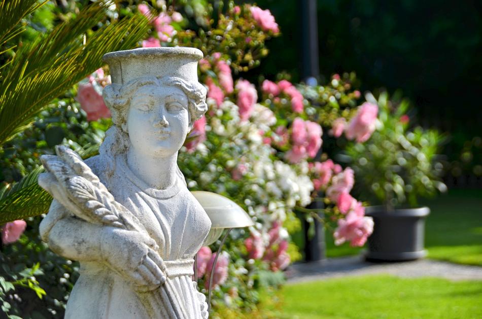 female Figure with ears of crop, Statue in Garden among flowers
